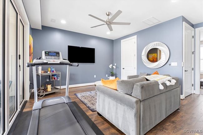 Living area featuring dark wood-style flooring, a ceiling fan, visible vents, and baseboards | Image 28