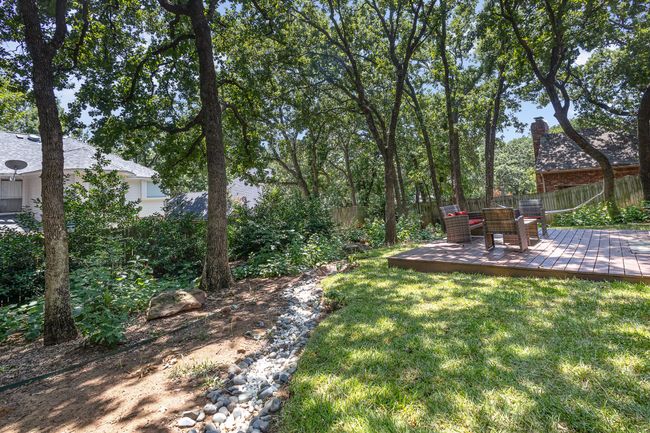 Fenced backyard with lots of native plants and large trees | Image 29