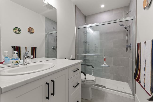Full bath featuring vanity, toilet, a stall shower, tile patterned flooring, and recessed lighting | Image 34