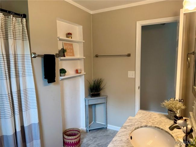 Full bath with vanity, crown molding, a shower with curtain, and baseboards | Image 12