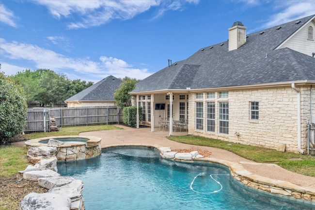 View of pool with a fenced backyard, a patio area, and a pool with connected hot tub | Image 8