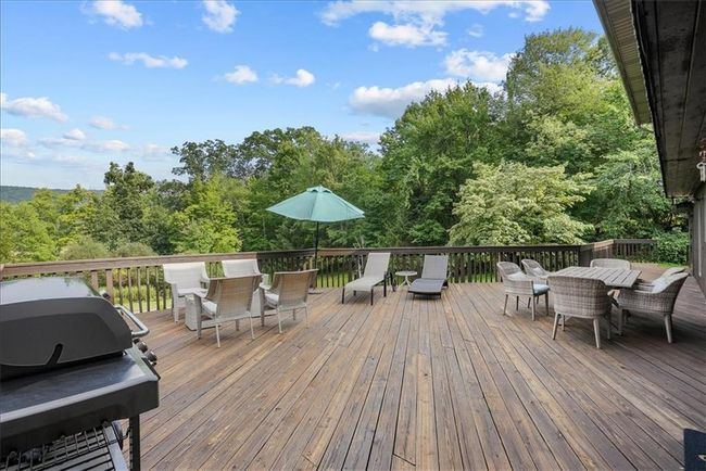 Deck with outdoor dining space and a grill | Image 44