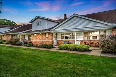 Back house at dusk with covered porch and a lawn | Image 2