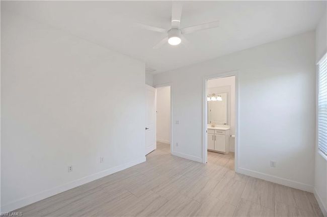 Unfurnished bedroom featuring baseboards, connected bathroom, and a ceiling fan | Image 19