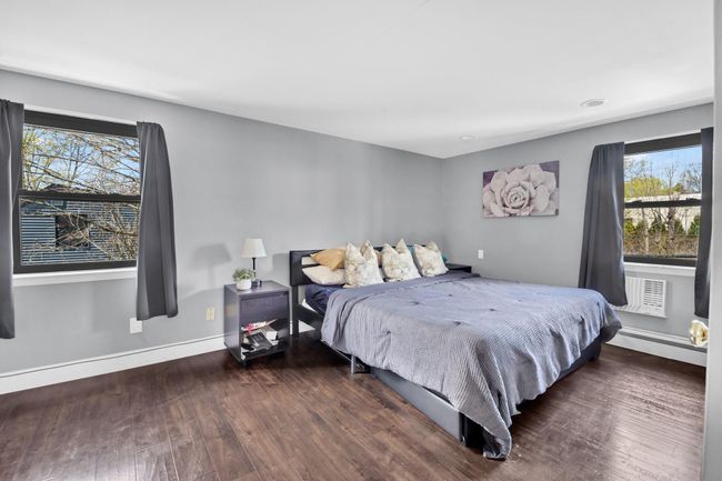 Bedroom with baseboards, wood finished floors, and multiple windows | Image 15