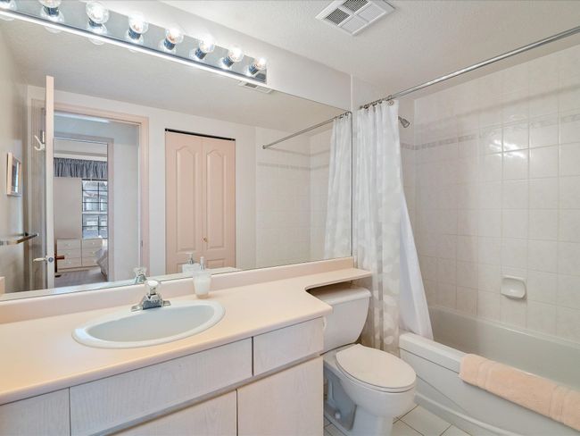 Full bath with a textured ceiling, toilet, vanity, visible vents, and shower / tub combo with curtain | Image 21
