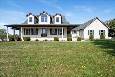 Farmhouse-style home featuring a front yard and a porch | Image 2