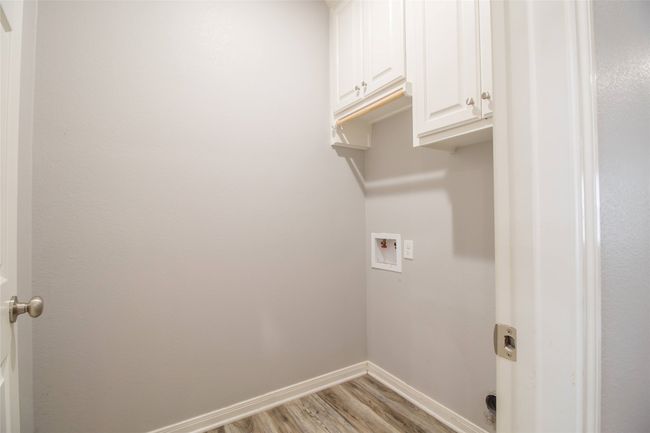 Washroom featuring cabinet space, washer hookup, and light wood finished floors | Image 7