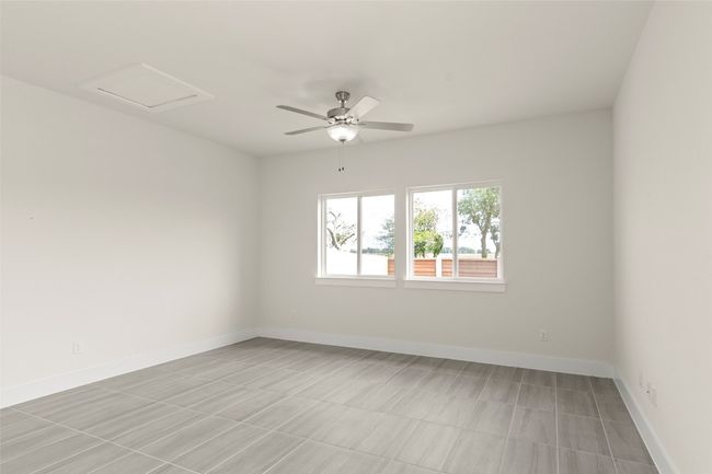 Spare room featuring a ceiling fan, baseboards, and attic access | Image 6