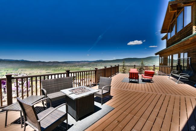 Deck featuring a mountain view and an outdoor living space with a fire pit | Image 55