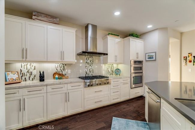 Stylish cabinetry, Slab counters, 6-burner gas range, stainless steel appliances, large island looking out into the Greatroom and outdoor entertaining areas. | Image 14