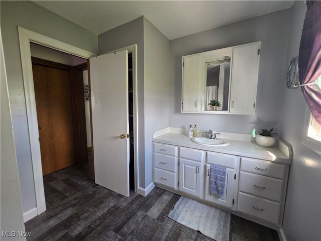 Bathroom with baseboards, wood finished floors, and vanity | Image 10