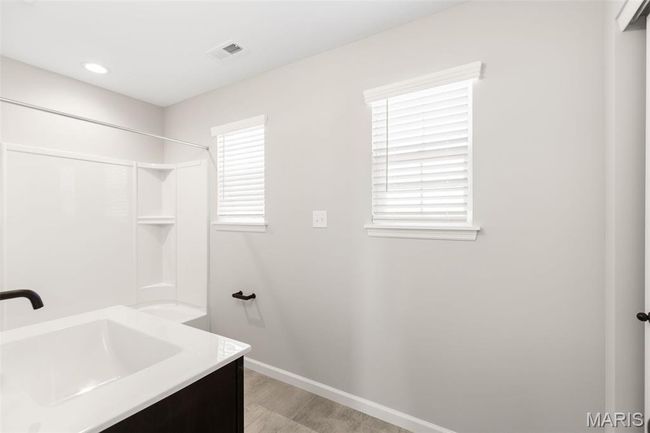 Bathroom featuring baseboards, vanity, and tub / shower combination | Image 14