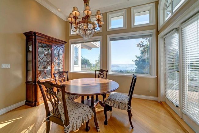 Dining room with light wood-type flooring, baseboards, a chandelier, and ornamental molding | Image 15