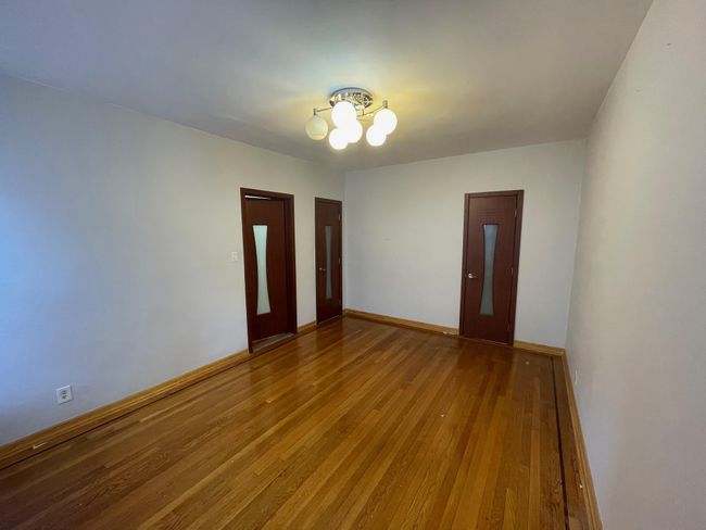 Unfurnished room featuring wood-type flooring, baseboards, and an inviting chandelier | Image 11