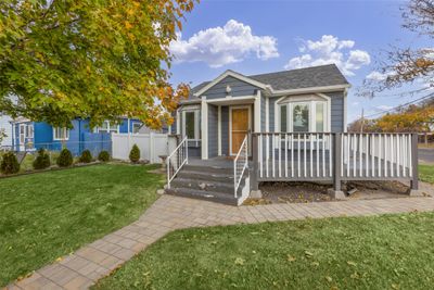 Bungalow-style house featuring a front yard and a deck | Image 1