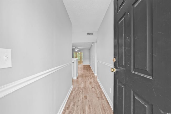 Hallway featuring light wood-style flooring and an upstairs landing | Image 5