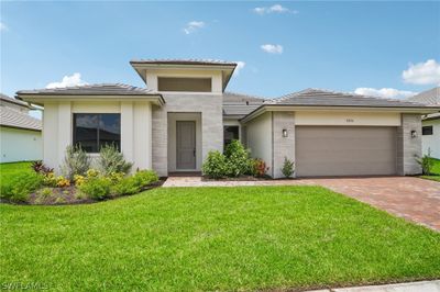 View of front facade with a front yard and a garage | Image 1