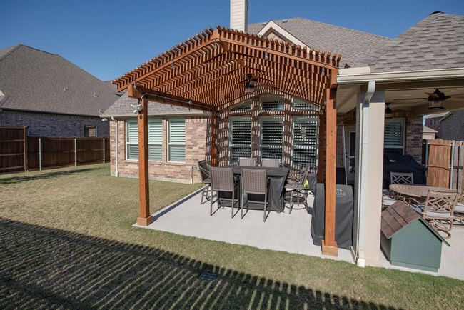 Fenced backyard with a pergola, ceiling fan, and a patio | Image 34