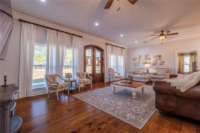 Living room with dark hardwood / wood-style floors, ceiling fan, and crown molding | Image 7