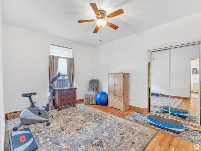Exercise room with baseboards, wood finished floors, and ceiling fan | Image 26