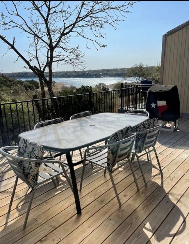 Wooden terrace featuring outdoor dining area, a water view, and grilling area | Image 4