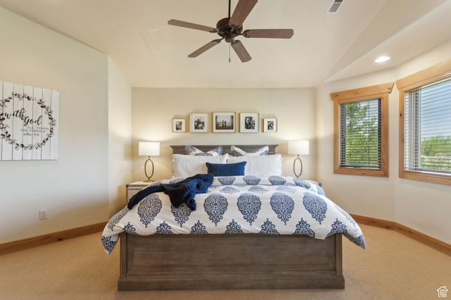 Bedroom with carpet floors, baseboards, lofted ceiling, and ceiling fan | Image 26