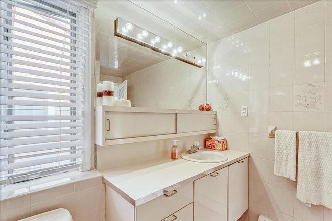 Half bath with tile walls, vanity, and radiator heating unit | Image 19