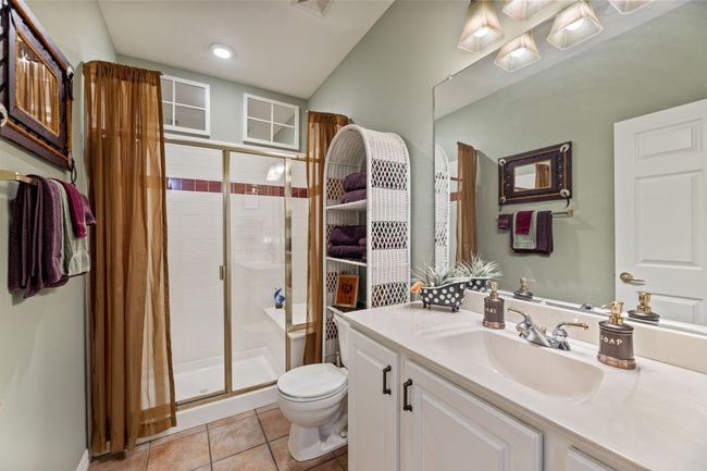 Full bathroom featuring a stall shower, toilet, tile patterned floors, and vanity | Image 29