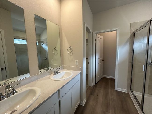 Bathroom with a shower stall, wood finished floors, and double vanity | Image 7