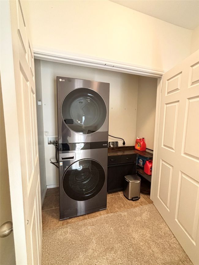 Laundry room featuring stacked washer / drying machine and light carpet | Image 16