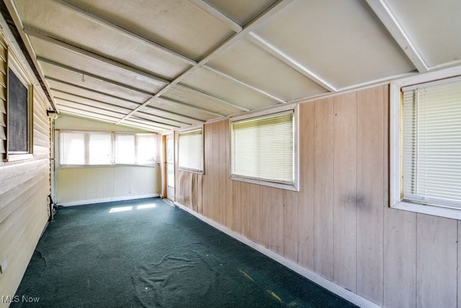 Unfurnished sunroom featuring lofted ceiling | Image 36