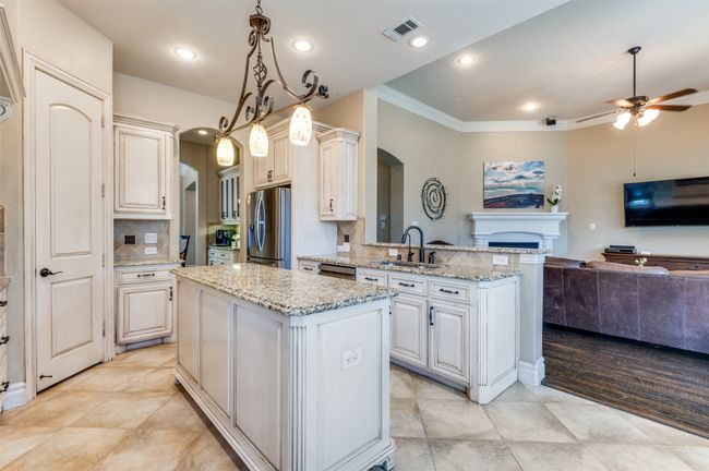 Kitchen featuring visible vents, open floor plan, a peninsula, arched walkways, and stainless steel appliances | Image 17