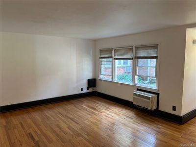 Large sun filled living room with refinished hardwood floors. | Image 2