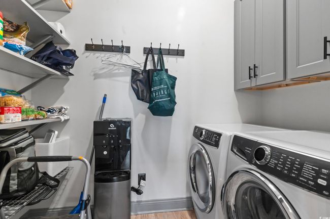 Washroom with light wood finished floors, washer and dryer, and cabinet space | Image 27