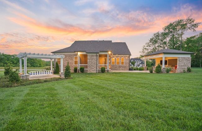 Over an acre of beautifully maintained land—where do you want to sit while watching the sunset? Under the pergola swing, in the cozy screened-in porch, or beneath the outdoor kitchen pavilion? The choice is all yours! | Image 9