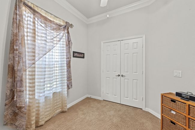 Unfurnished bedroom featuring crown molding, carpet flooring, a closet, baseboards, and a ceiling fan | Image 9