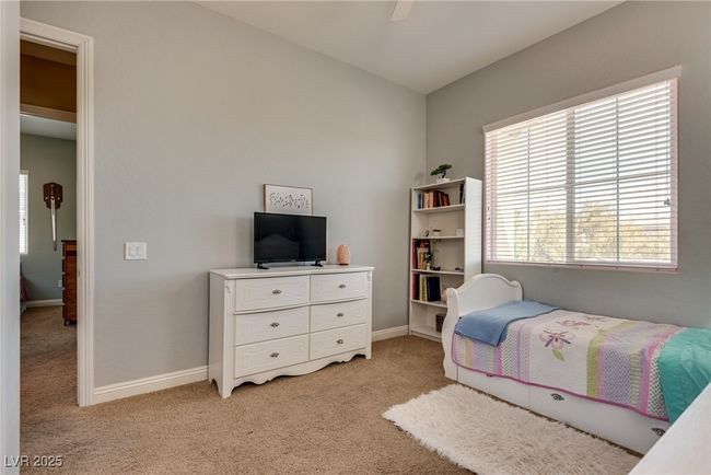 Bedroom featuring a ceiling fan, baseboards, and light colored carpet | Image 39