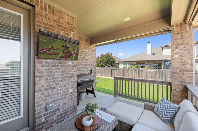 Covered back patio creates the perfect outdoor living room—ideal for watching the game, grilling, or unwinding in the shade. | Image 29