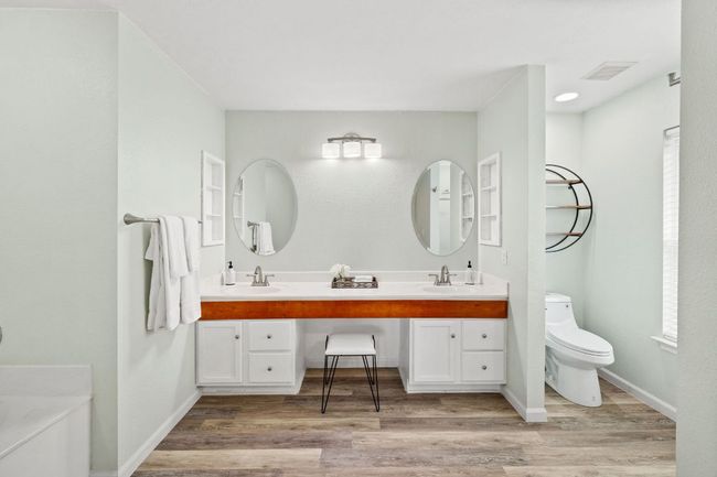 Full bath featuring double vanity, wood finished floors, toilet, and baseboards | Image 32