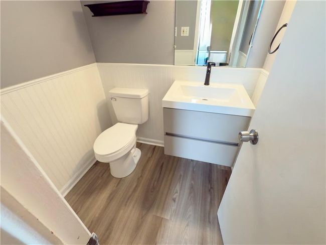 Bathroom with wainscoting, wood finished floors, toilet, and vanity | Image 7