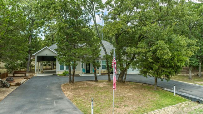Obstructed view of property featuring asphalt driveway, a shingled roof, and stone siding | Image 35