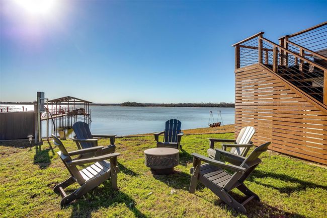 View of grassy yard with a water view, boat lift, and a boat dock | Image 5