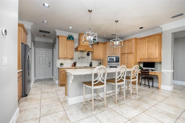 Fully upgraded kitchen with stainless steel appliances, custom cabinets, granite counters, large island with seating, and much more! | Image 6