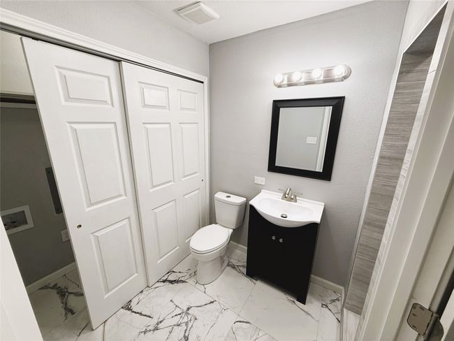 Half bath featuring vanity, toilet, marble ffloor | Image 12