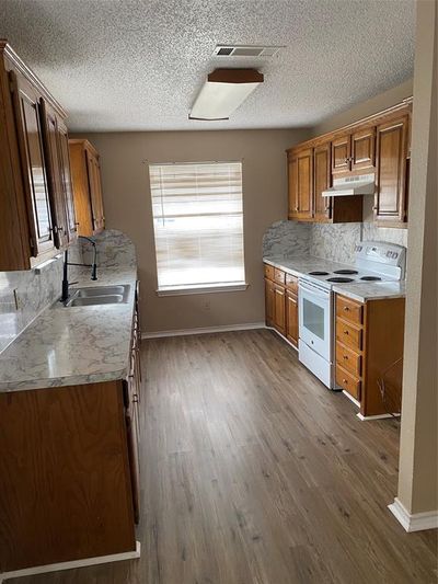 Kitchen with range, hardwood / wood-style flooring, and a wealth of natural light | Image 2