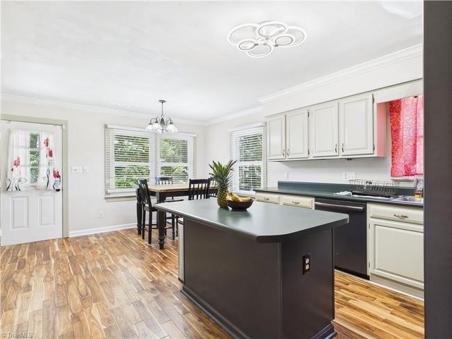Large eat in kitchen featuring lots of counter space and cabinets | Image 10