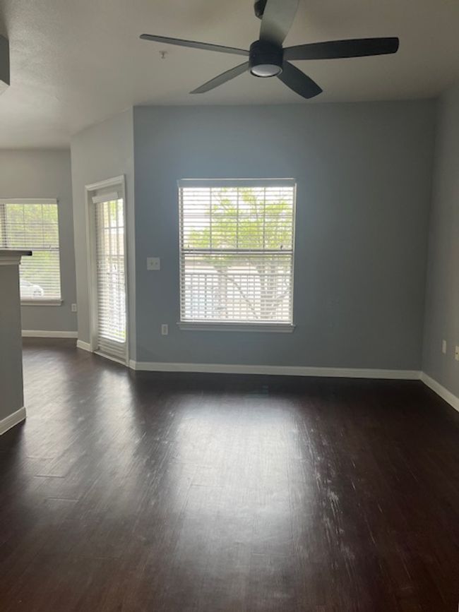 Empty room featuring a ceiling fan, baseboards, and dark wood-type flooring | Image 5
