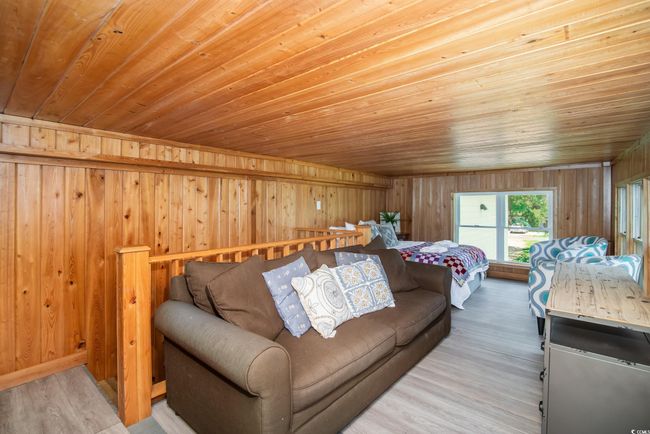 Bedroom with wood ceiling, wood walls, and wood finished floors | Image 12