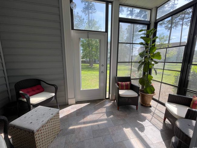 Sunroom featuring a healthy amount of sunlight, Parklike View, Tiled Floor, Ceiling Fan and EZ Breeze Windows allowing for 3 Season usage! | Image 25
